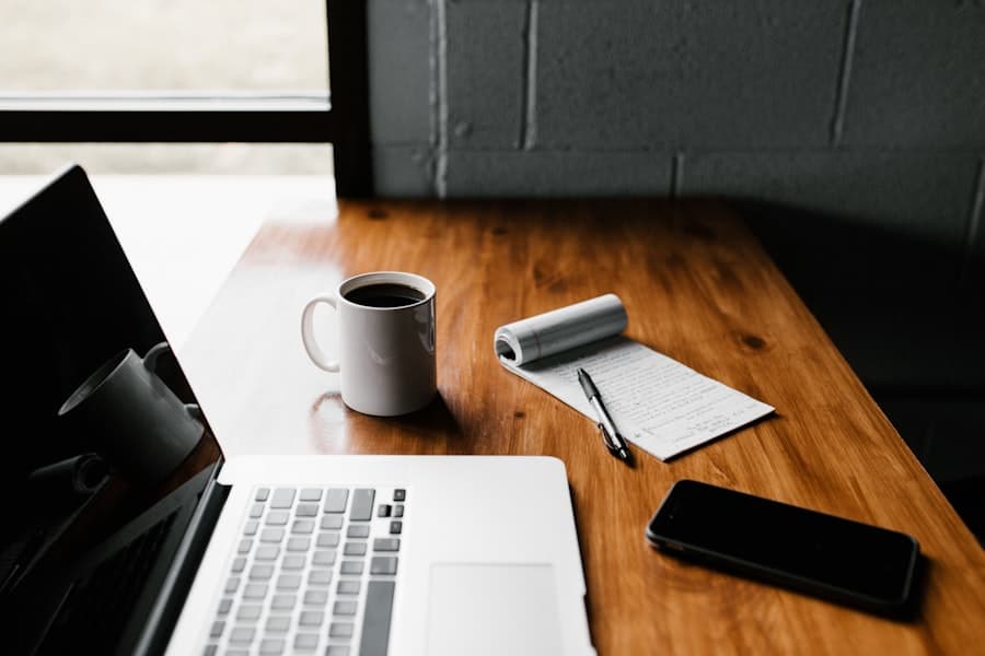 Schreibtisch mit Laptop, Kaffee und handschriftlichen Gesprächsnotizen